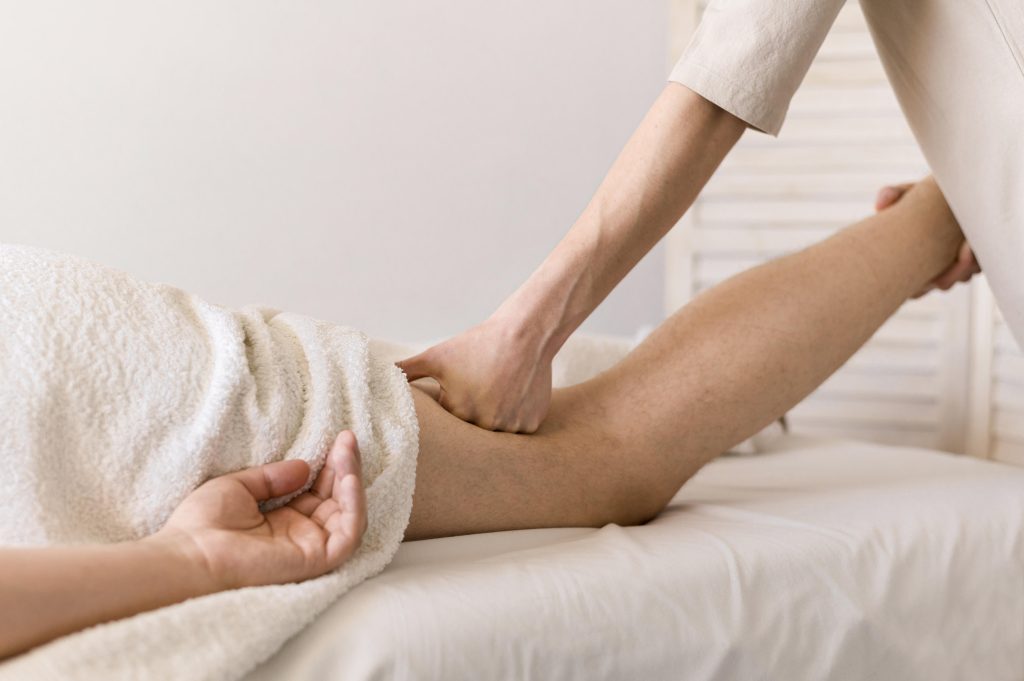 Thérapeute effectuant un massage à l'aide de son poing sur la cuisse de son client
