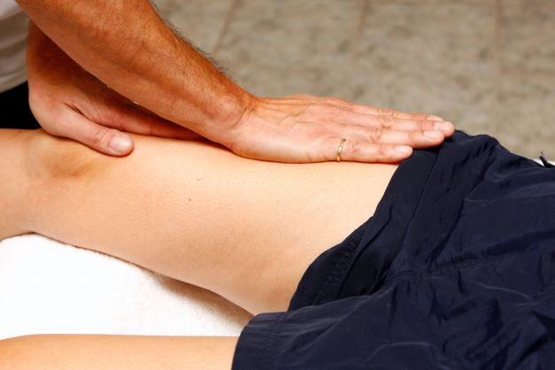 Gros plan d'une main effectuant un massage sur une cuisse