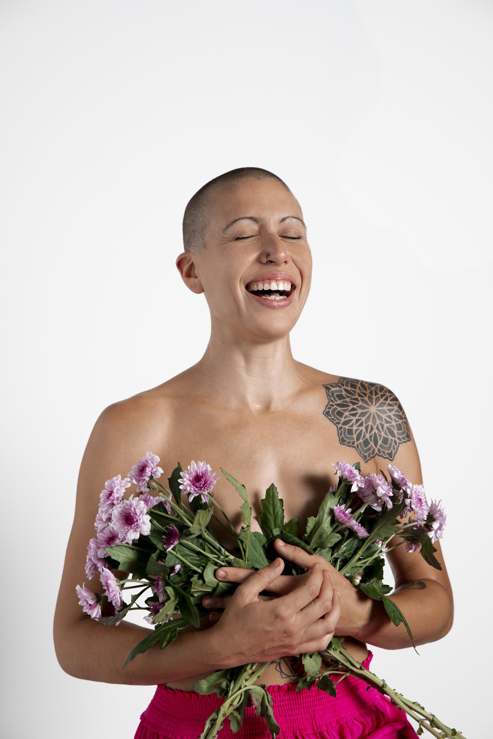 Femme atteinte de cancer se couvrant la poitrine avec un bouquet de fleurs