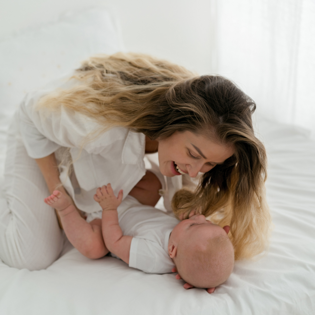Mère jouant avec son bébé qui est couché sur le dos