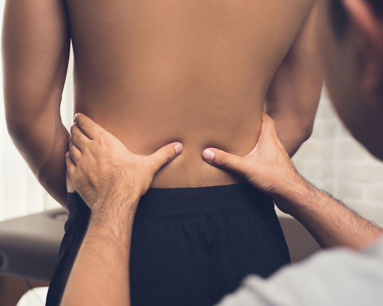 Orthothérapeute effectuant une observation du bas du dos de son client