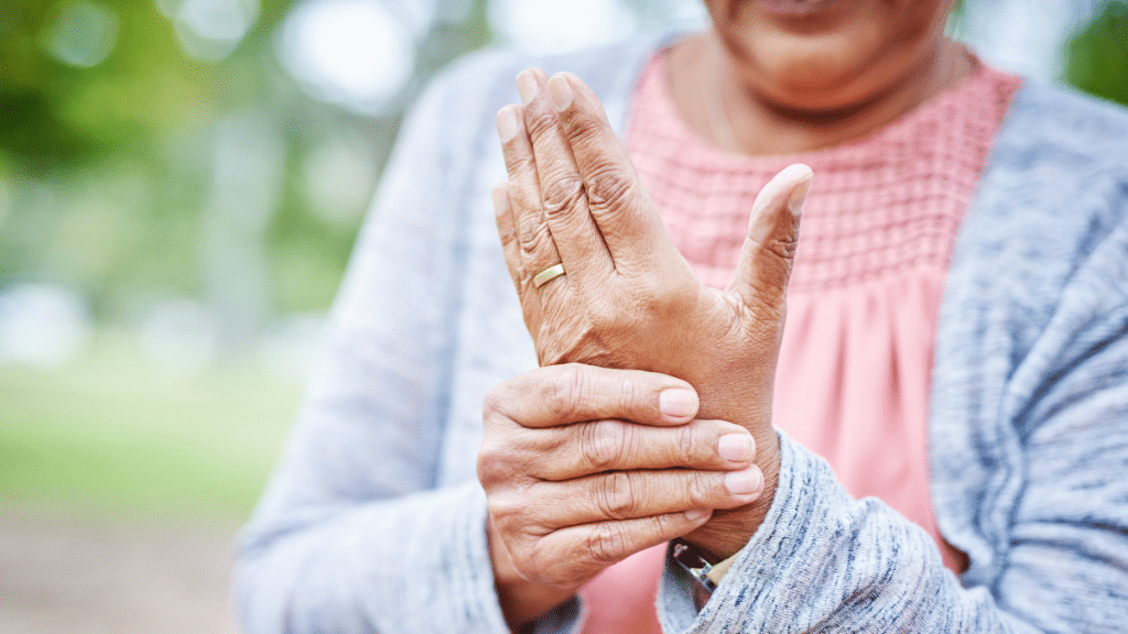 Gros plan sur une personne âgée qui se prend la main car elle souffre d'arthrite